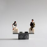 Miniatura de mujer y hombre en una balanza