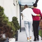 Dos personas caminan hacia una casa