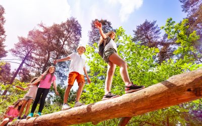 Niños caminando sobre un tronco