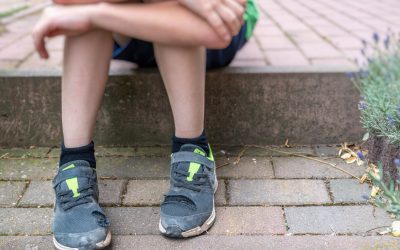 Un niño viste unos zapatos desgastados.