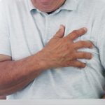 Hombre con la mano apretada en su pecho