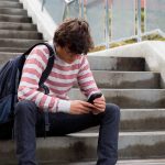 Joven con móvil en unas escaleras