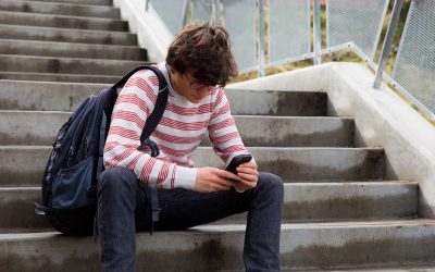 Joven con móvil en unas escaleras